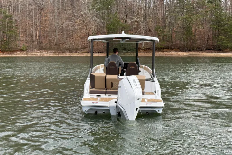 Slide: The Image of 2026 Monterey Elite 25 OB boat cruising on a calm lake with wooded shoreline. - 4