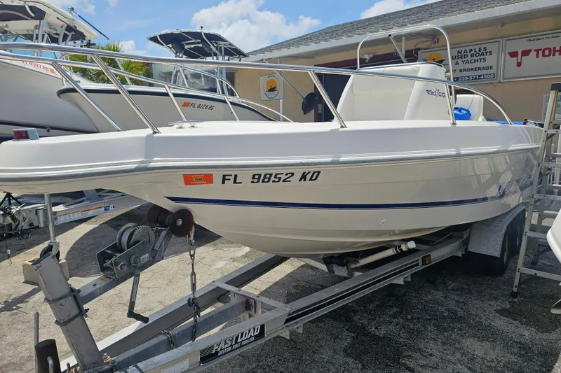 The Image of 1997 Wellcraft 190 CCF boat on trailer, displayed at a dealership under sunny skies. - 1