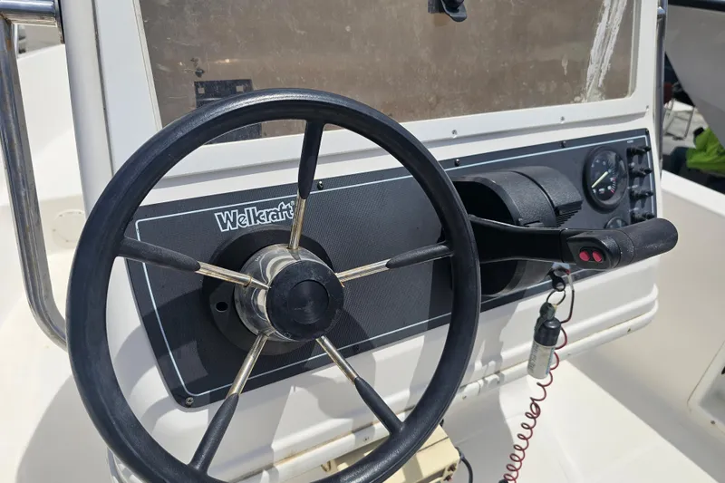 Slide: The Image of Steering console of a 1997 Wellcraft 190 CCF boat, featuring a black steering wheel. - 12