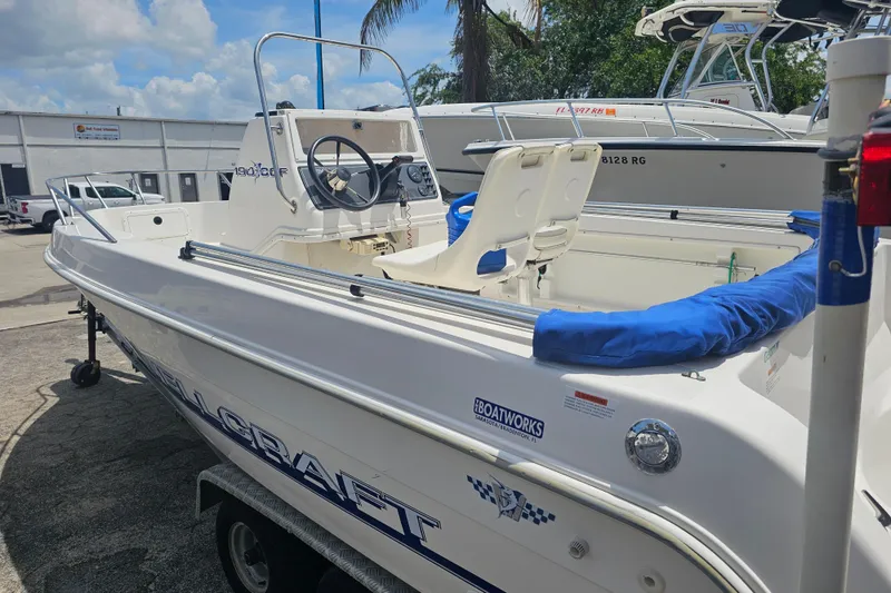 Slide: The Image of 1997 Wellcraft 190 CCF boat with blue accents, parked outdoors on a sunny day. - 4
