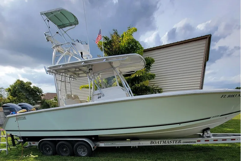 The Image of 2008 Jupiter 34 FS boat on trailer, parked outdoors under cloudy sky. - 0