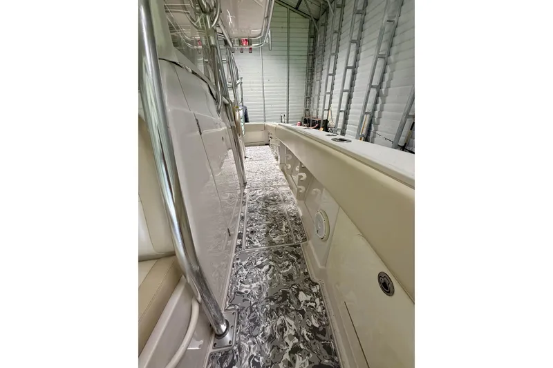 Slide: The Image of 2008 Jupiter 34 FS boat interior with sleek design and patterned flooring in a storage facility. - 19