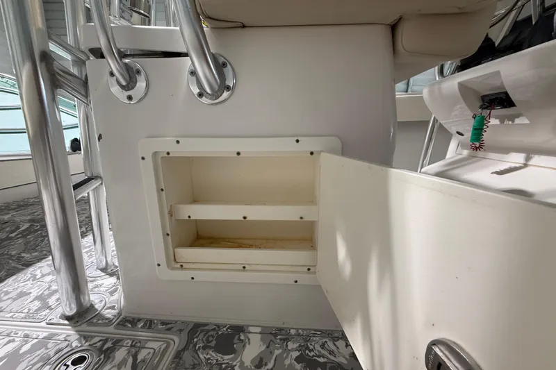 Slide: The Image of Storage compartment on a 2008 Jupiter 34 FS boat, featuring open shelving and metal railings. - 28