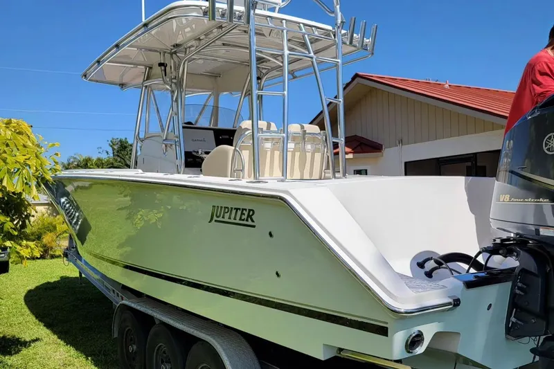 Slide: The Image of 2008 Jupiter 34 FS boat with dual engines on a trailer, parked in a sunny yard. - 3