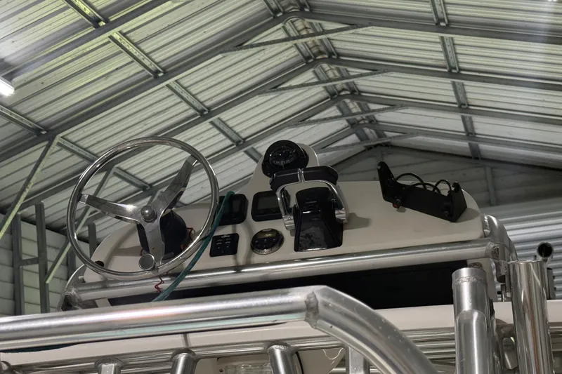 Slide: The Image of 2008 Jupiter 34 FS boat helm with steering wheel and controls in a metal-roofed garage. - 31