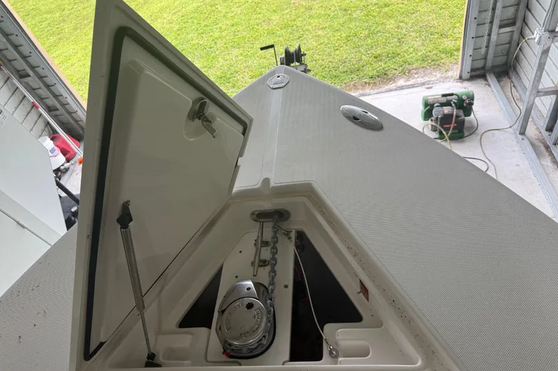 Slide: The Image of Open anchor compartment on a 2008 Jupiter 34 FS boat in a garage setting. - 33