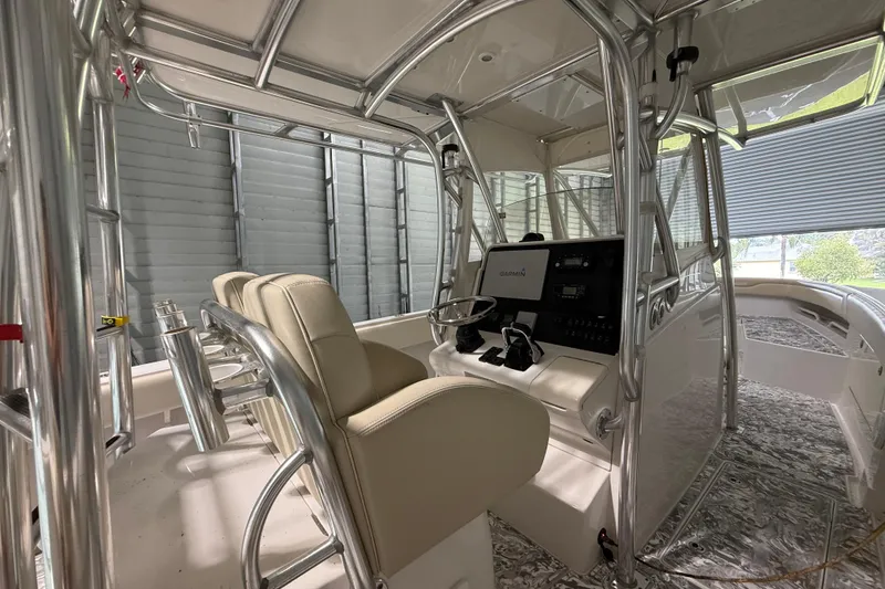Slide: The Image of 2008 Jupiter 34 FS boat interior with helm, Garmin electronics, and cushioned seating. - 8