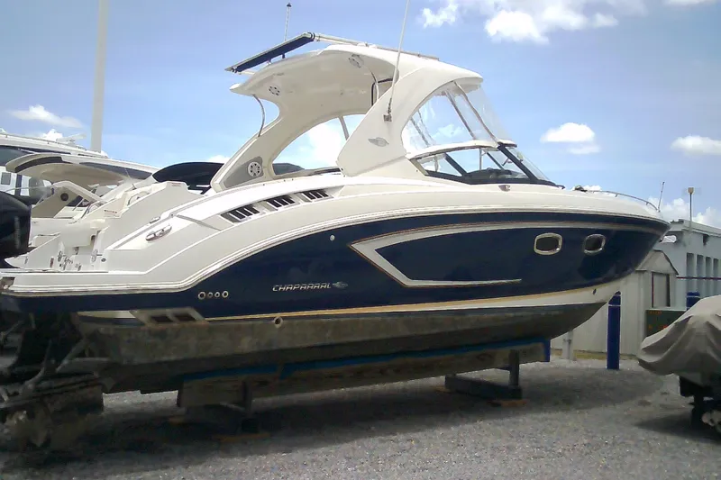 Slide: The Image of 2013 Chaparral 327 SSX boat on display under a clear blue sky. - 0