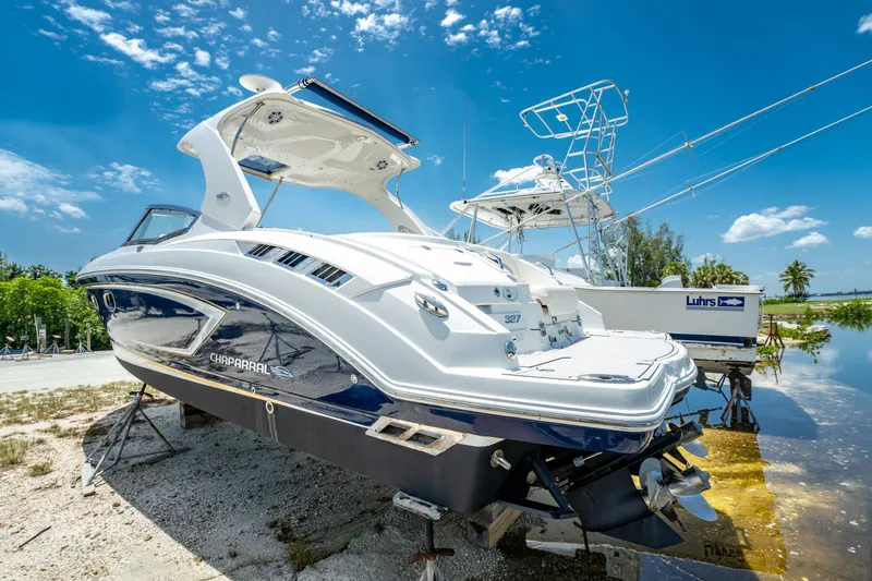 Slide: The Image of 2013 Chaparral 327 SSX boat on land under a clear blue sky. - 73