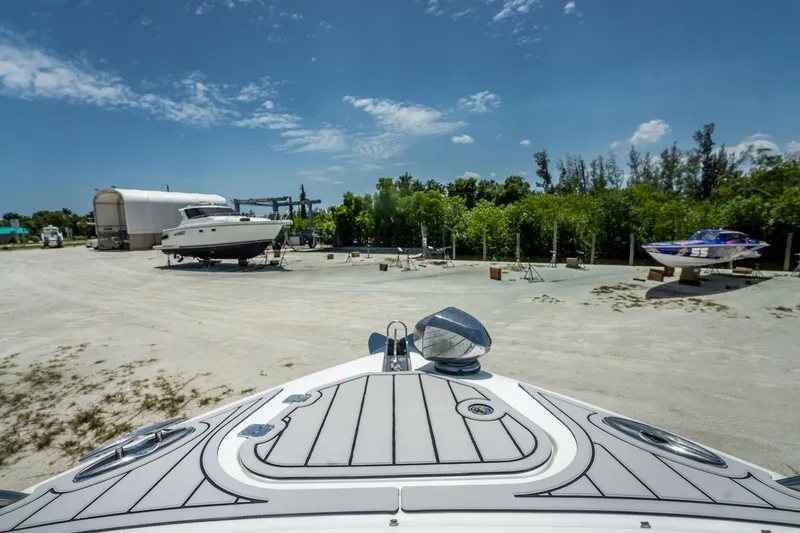 Slide: The Image of Chaparral 327 SSX boat in a sunny marina with other boats and greenery. - 60