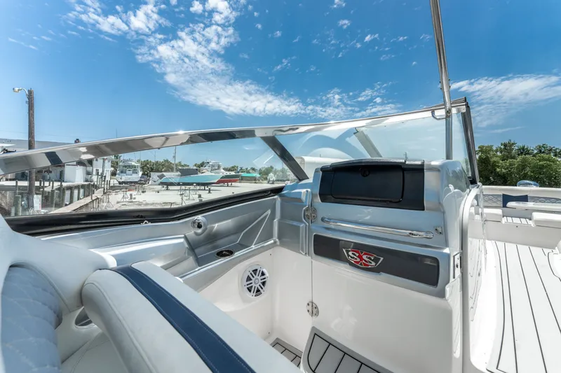 Slide: The Image of 2013 Chaparral 327 SSX boat interior with sleek dashboard and clear blue sky. - 54