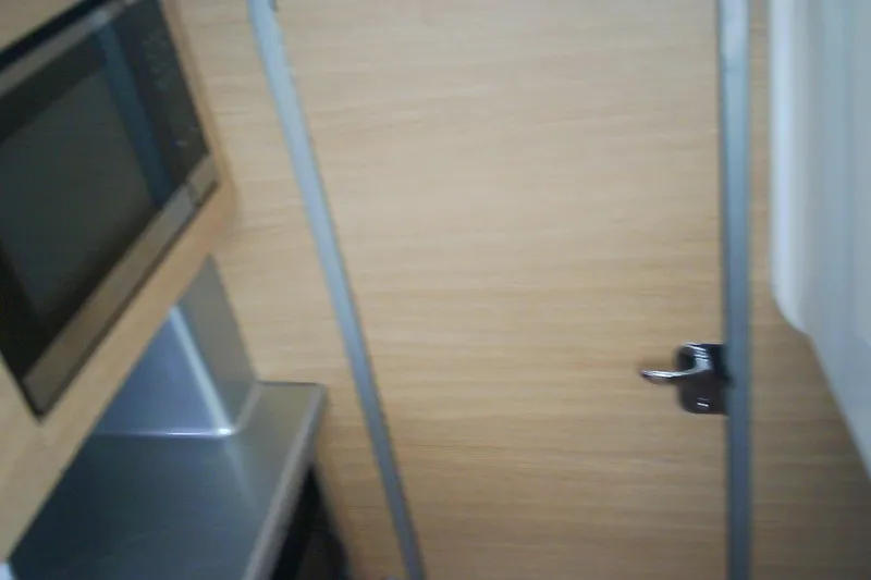 Slide: The Image of Interior view of 2013 Chaparral 327 SSX boat with microwave and wooden door. - 26