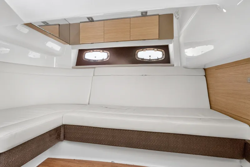 Slide: The Image of Interior cabin of 2013 Chaparral 327 SSX boat with white seating and wooden cabinets. - 43