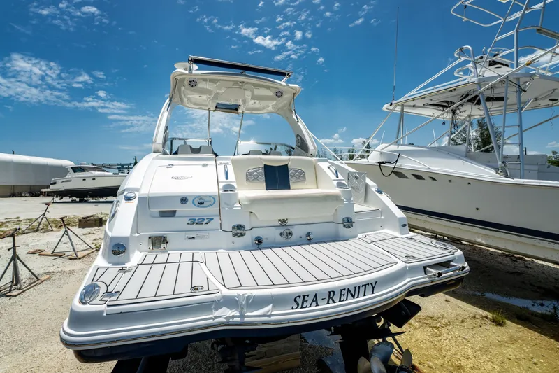 Slide: The Image of 2013 Chaparral 327 SSX boat named "Sea-Renity" on dry dock under a clear blue sky. - 76