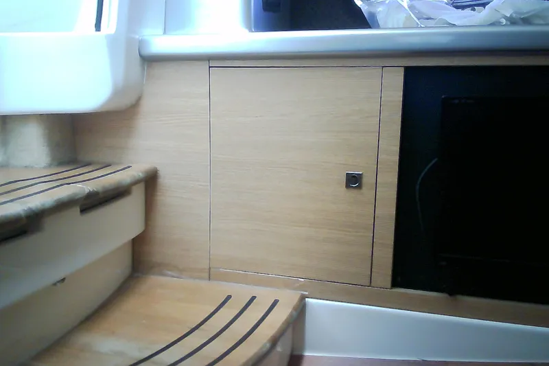 Slide: The Image of Interior of 2013 Chaparral 327 SSX boat with wooden cabinetry and steps. - 33