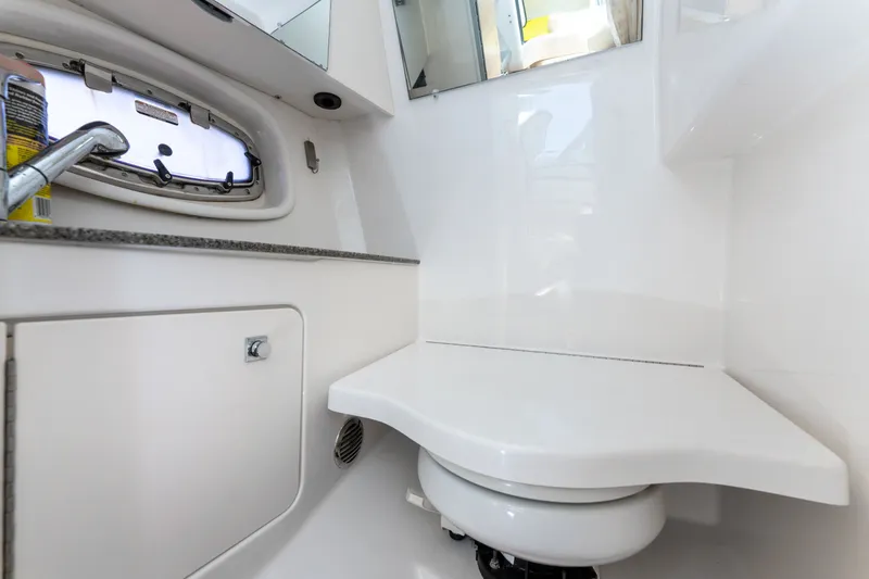 Slide: The Image of 2013 Chaparral 327 SSX boat bathroom with white interior and compact design. - 37