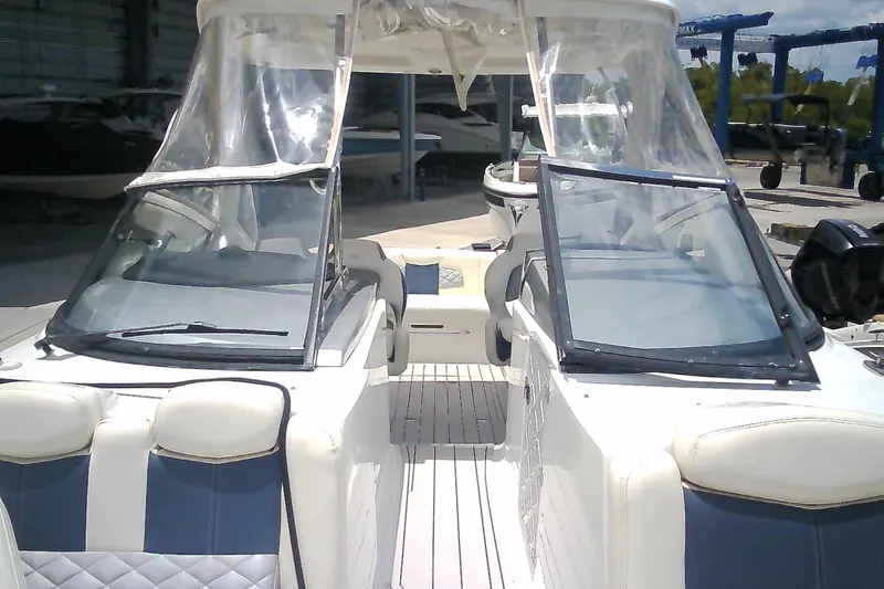 Slide: The Image of 2013 Chaparral 327 SSX boat interior with seating and windshield in a marina setting. - 5