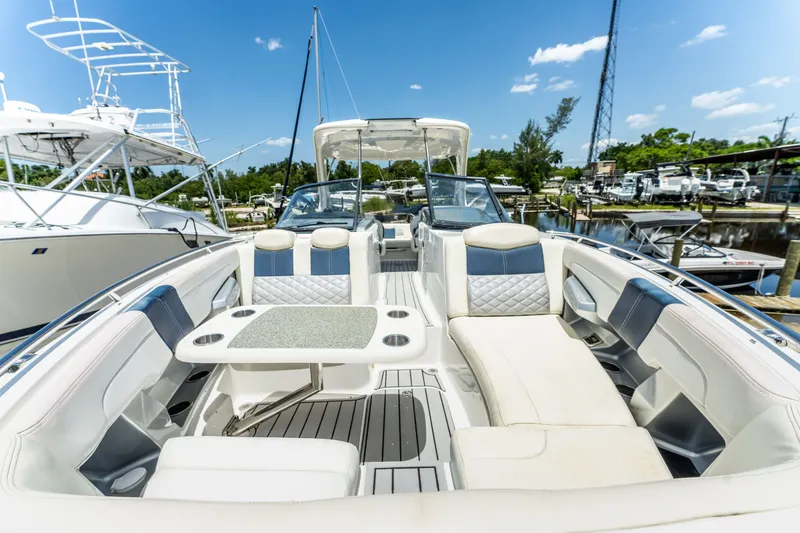 Slide: The Image of 2013 Chaparral 327 SSX boat interior with luxurious seating and table, docked at marina. - 62