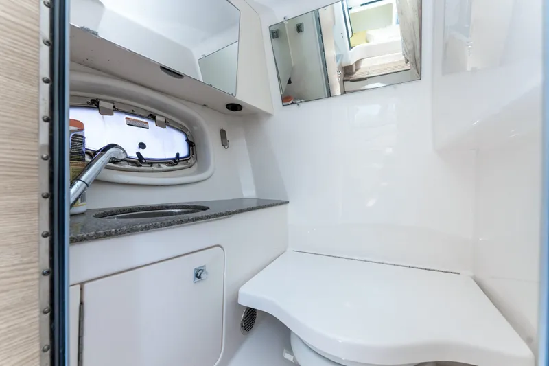 Slide: The Image of 2013 Chaparral 327 SSX boat bathroom with sink, mirror, and porthole window. - 45