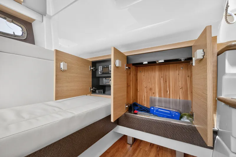 Slide: The Image of Interior storage area of 2013 Chaparral 327 SSX boat with open wooden cabinets. - 35