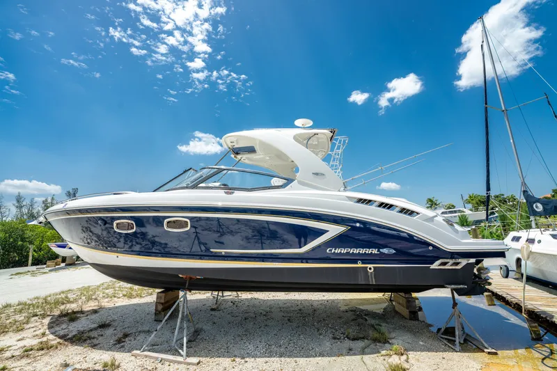 Slide: The Image of 2013 Chaparral 327 SSX boat on dry dock under a clear blue sky. - 83