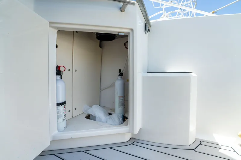 Slide: The Image of Storage compartment on 2013 Chaparral 327 SSX boat with fire extinguishers. - 70