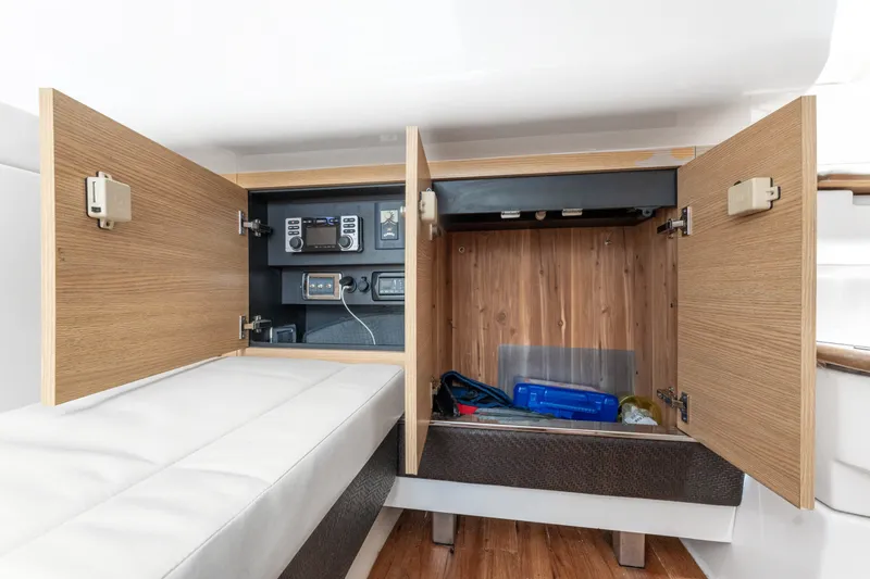 Slide: The Image of 2013 Chaparral 327 SSX boat interior storage with open cabinets and electronic controls. - 44