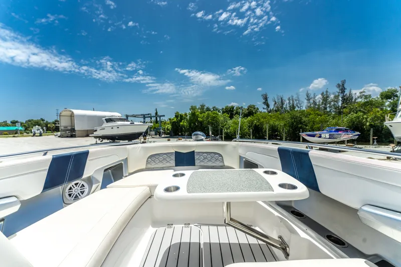 Slide: The Image of 2013 Chaparral 327 SSX boat interior with seating and table under clear blue sky. - 59