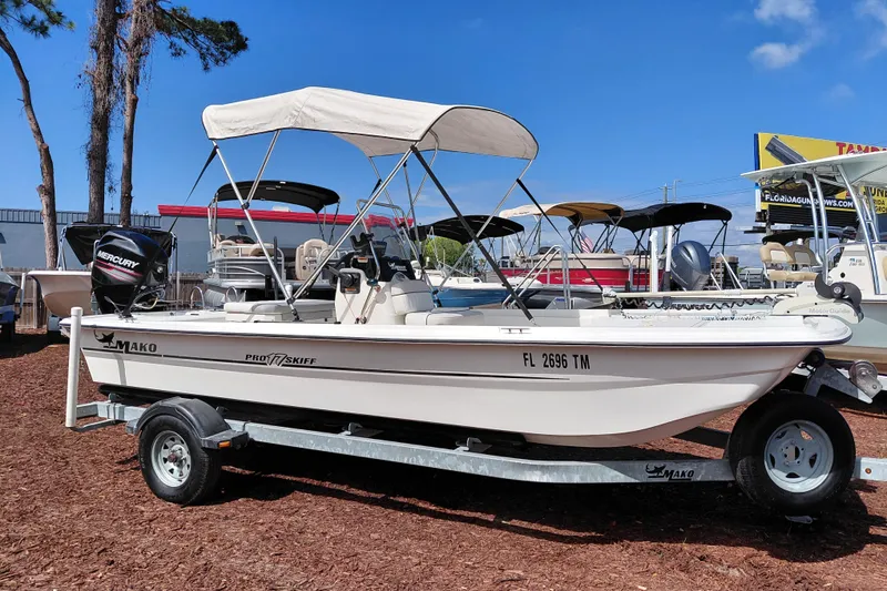The Image of 2015 Mako Pro Skiff 17 CC boat on trailer with canopy, parked outdoors. - 1