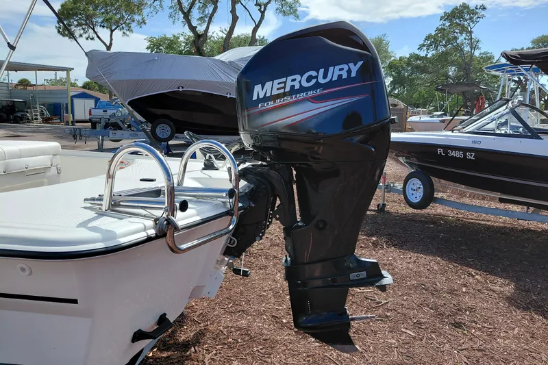 Slide: The Image of 2015 Mako Pro Skiff 17 CC with Mercury FourStroke outboard motor in a boatyard. - 11