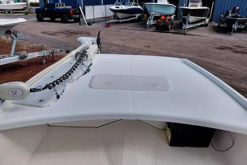 Slide: The Image of 2015 Mako Pro Skiff 17 CC boat deck with trolling motor in a marina setting. - 19