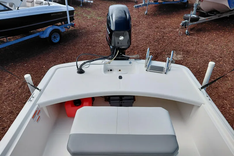 Slide: The Image of 2015 Mako Pro Skiff 17 CC boat interior with motor and seating. - 26