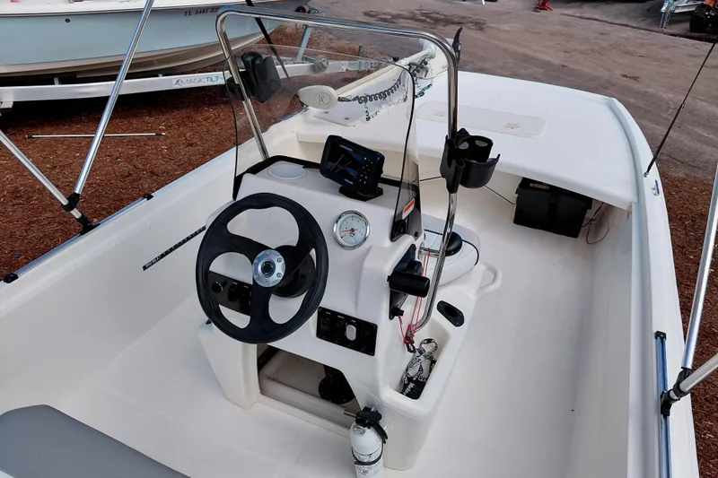 Slide: The Image of 2015 Mako Pro Skiff 17 CC boat interior with steering wheel and control panel. - 28