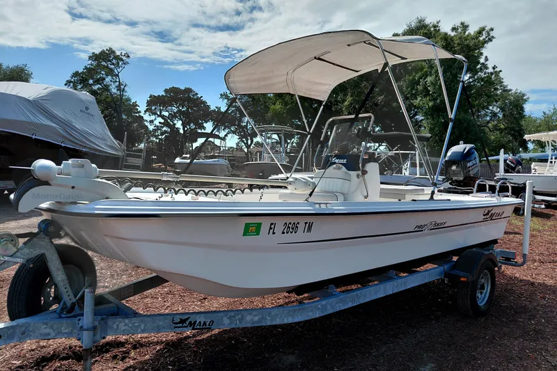 Slide: The Image of 2015 Mako Pro Skiff 17 CC boat on trailer with canopy, parked outdoors. - 3