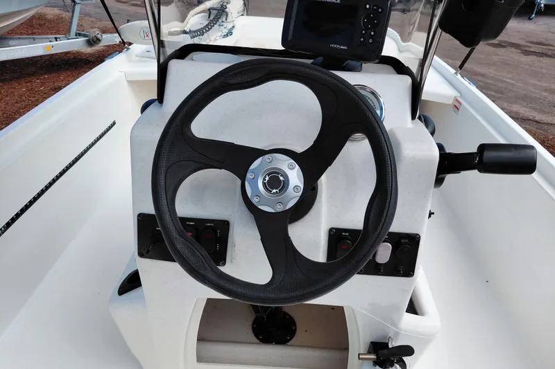 Slide: The Image of Steering console of a 2015 Mako Pro Skiff 17 CC boat with controls and display. - 33