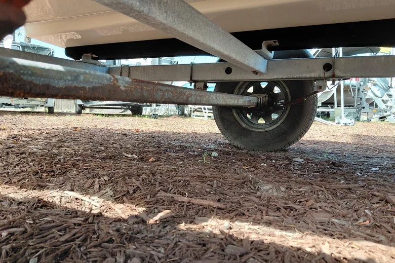 Slide: The Image of 2015 Mako Pro Skiff 17 CC trailer underside with visible wheel and rusted metal parts. - 40