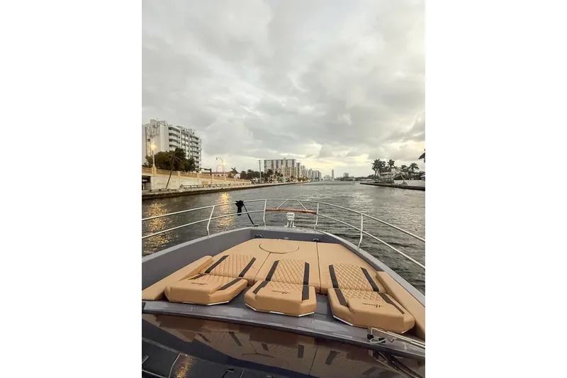 Slide: The Image of Luxurious Hanover 387 yacht cruising through a scenic urban waterway, 2027 model. - 2