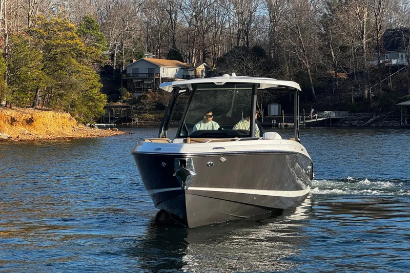 Slide: The Image of 2026 Monterey Elite 30 OB boat cruising on a scenic lake with wooded shoreline. - 10