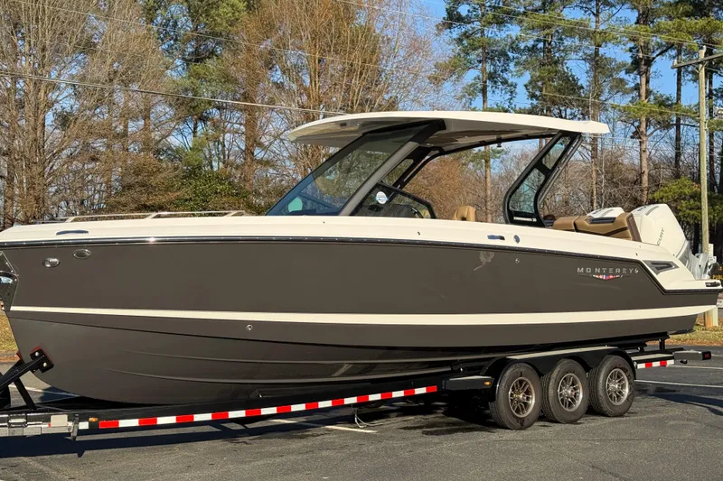 Slide: The Image of 2026 Monterey Elite 30 OB boat on trailer, sleek design, parked outdoors. - 12