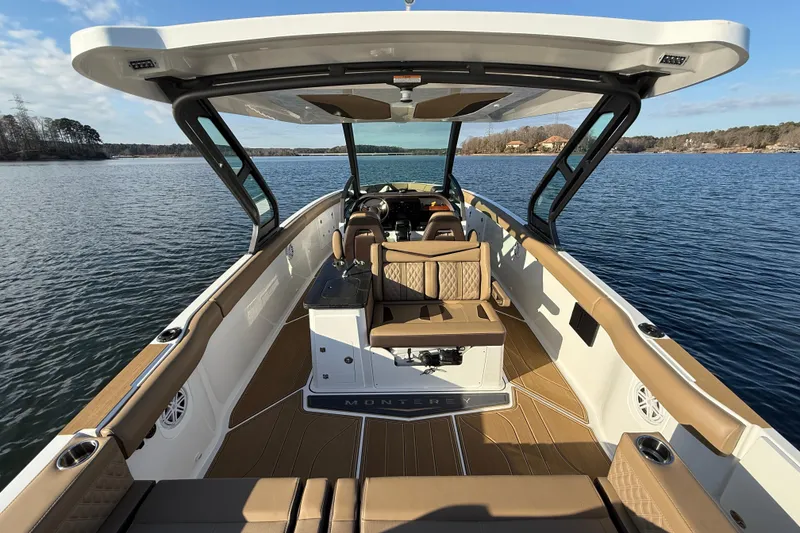 Slide: The Image of 2026 Monterey Elite 30 OB boat interior with luxurious seating on a serene lake. - 15