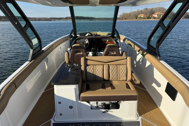 Slide: The Image of 2026 Monterey Elite 30 OB boat interior with luxurious seating on a serene lake. - 16
