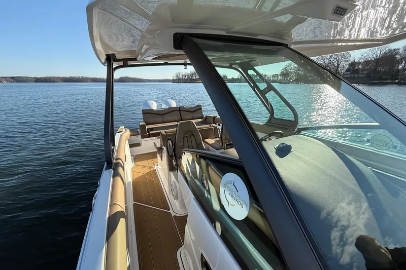 Slide: The Image of 2026 Monterey Elite 30 OB boat on serene lake, showcasing luxurious interior and sleek design. - 18