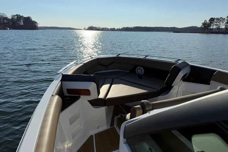 Slide: The Image of 2026 Monterey Elite 30 OB boat on serene lake with sunlit water and plush seating. - 25