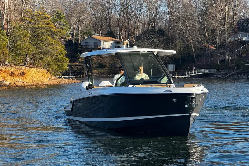 Slide: The Image of 2026 Monterey Elite 30 OB boat cruising on a scenic lake with wooded shoreline. - 3