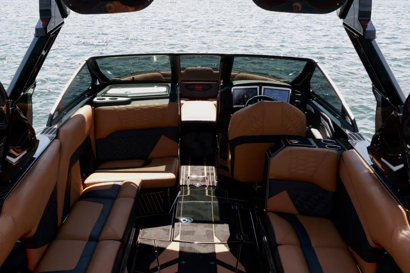 Slide: The Image of 2024 Centurion Ri265 boat interior with luxurious seating and modern dashboard on water. - 11