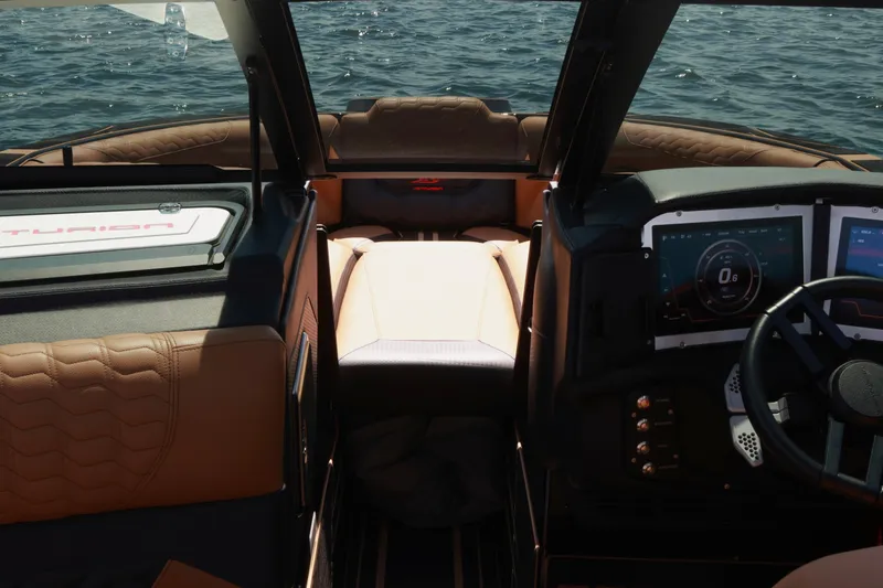 Slide: The Image of Interior of 2024 Centurion Ri265 boat with modern dashboard and seating, on water. - 12