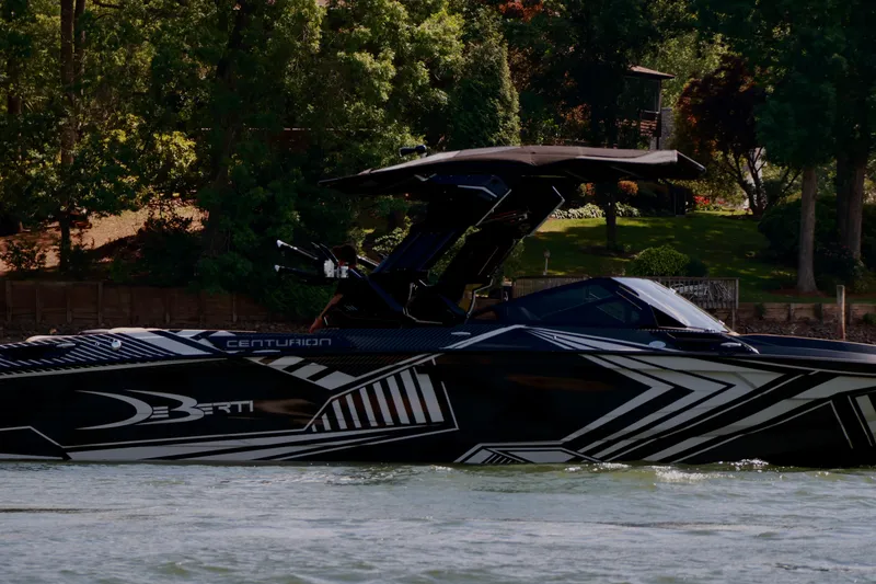 Slide: The Image of 2024 Centurion Ri265 boat with sleek design on a scenic lake. - 2