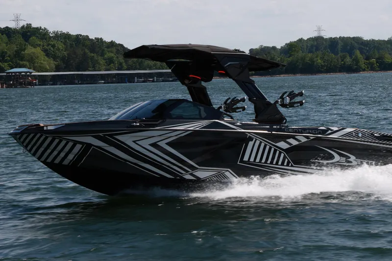 Slide: The Image of 2024 Centurion Ri265 boat cruising on a lake with modern design and graphics. - 7