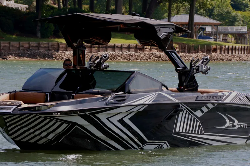 Slide: The Image of 2024 Centurion Ri265 boat with sleek black and white design on a lake. - 8
