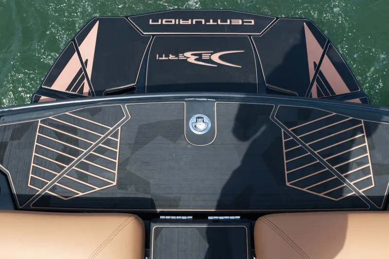 Slide: The Image of 2024 Centurion Ri265 boat deck with sleek design and logo, on water. - 9